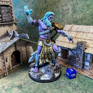 May include: A miniature figurine of a purple-skinned, bearded warrior with blue hair and a golden shoulder guard, holding a weapon. The figure stands on a rocky base, with a blue die nearby. Miniature buildings are in the background.