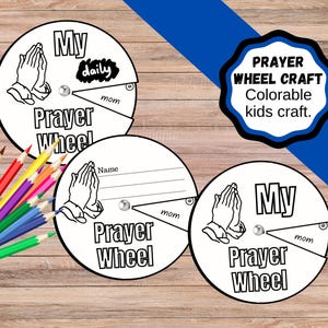 May include: A set of three white, circular prayer wheels with black text and illustrations, including praying hands. The wheels have sections for daily, name, and mom. A blue banner and a set of colored pencils are also visible.