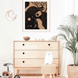 May include: A black and white illustration of a woman with long hair and a raven. The raven is perched on a branch with its wings spread. The woman is looking up at the raven. The illustration is framed and hanging on a white wall.