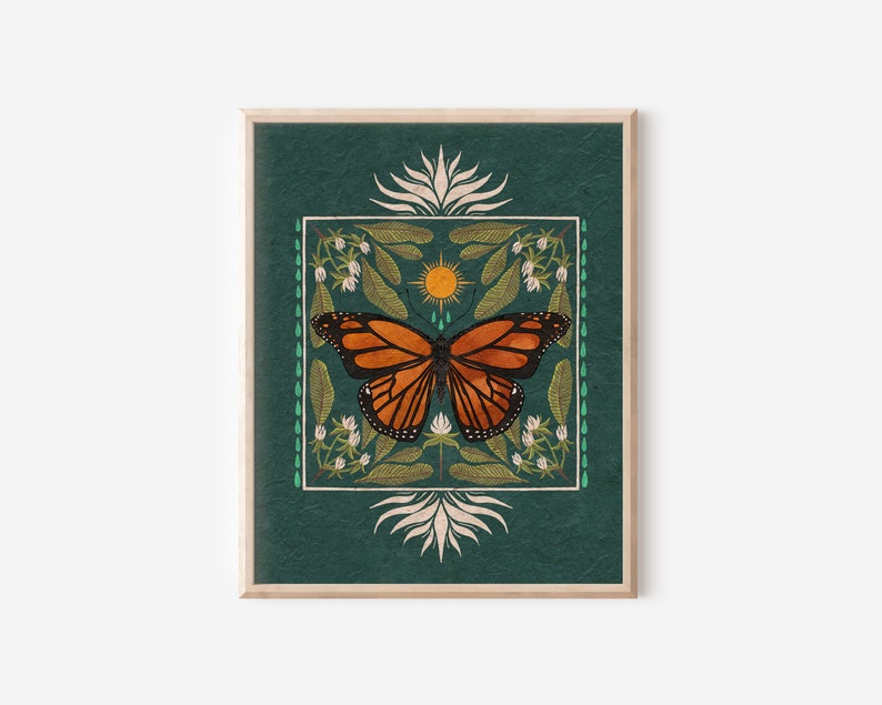 K&ouml;nnte beinhalten: Ein gerahmter Druck mit gr&uuml;nem Hintergrund, der einen Monarchfalter mit orangefarbenen und schwarzen Fl&uuml;geln, eine gelbe Sonne und wei&szlig;e Blumen zeigt. Das Design ist von einem Rand aus gr&uuml;nen Bl&auml;ttern und wei&szlig;en Blumen umgeben.