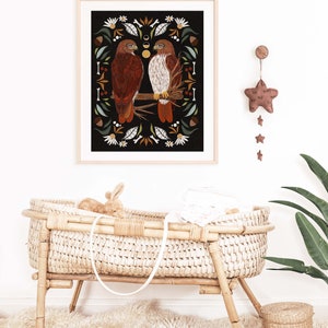 May include: A framed illustration of two red-tailed hawks perched on a branch, surrounded by a border of leaves, flowers, and acorns. The background is black, and the image has a rustic, vintage feel.