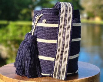 May include: A navy blue and white striped crocheted bag with a long strap and a tassel. The bag is made of cotton yarn and has a unique woven design.