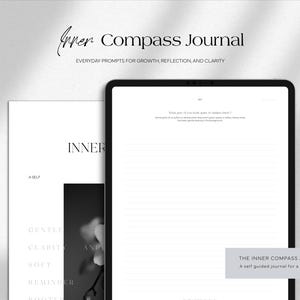 May include: A journal with the text "Inner Compass Journal" and "Everyday prompts for growth, reflection, and clarity". The journal is open to a blank page with lines. The cover of the journal is visible, with the word "INNER" and other text.