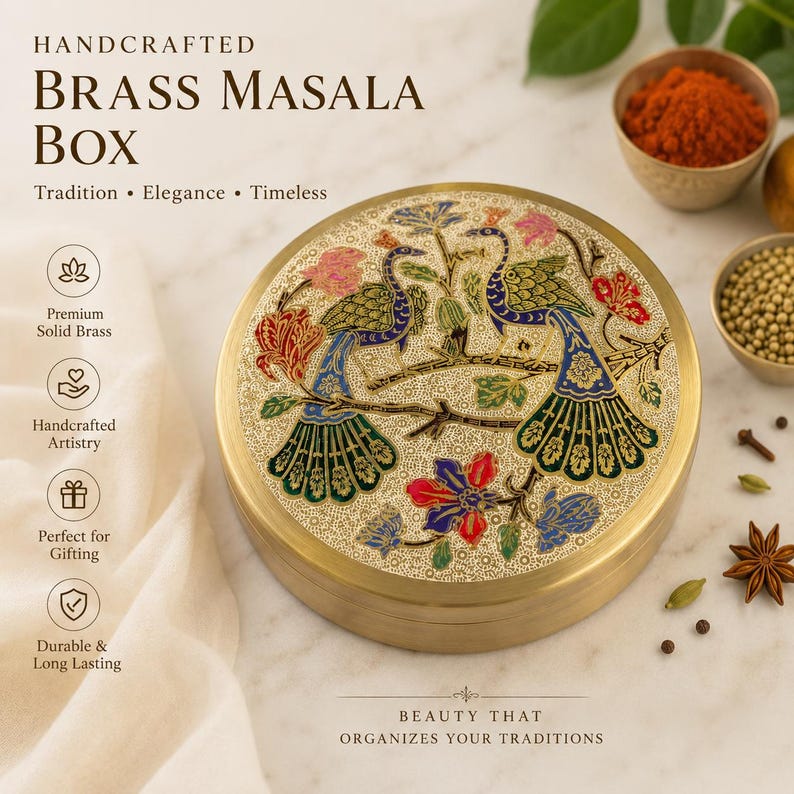 Op de afbeelding: Een ronde masala-doos van messing met een ingewikkeld gegraveerd ontwerp op het deksel, met twee pauwen op een tak omringd door bloemmotieven in blauwe, groene, rode en gouden tinten. De container heeft een gladde, metalen afwerking.