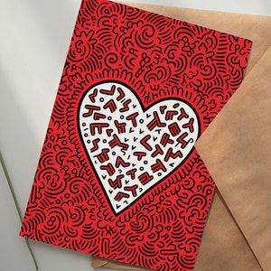 Puede incluir: Tarjeta de felicitaci&oacute;n roja con un dise&ntilde;o en forma de coraz&oacute;n blanco lleno de formas y texto abstractos. La tarjeta tiene un fondo de patr&oacute;n de garabatos negro y va acompa&ntilde;ada de un sobre marr&oacute;n. Adecuada para diversas ocasiones.