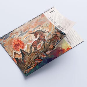 May include: A spiral-bound calendar featuring a vibrant illustration of a unicorn against a sunset backdrop. The artwork includes a red sun and detailed mountain scenery. The word "Februar" is visible at the top.