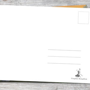 Puede incluir: Una postal blanca en blanco con l&iacute;neas para la direcci&oacute;n y un cuadro para el sello. La postal est&aacute; sobre un sobre marr&oacute;n y una tarjeta verde y amarilla. El logotipo de Graphic Kingdom est&aacute; en la esquina inferior derecha.