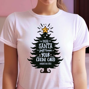 Maglietta per Natale. Design natalizio invernale. Design "Caro Babbo Natale, lascia semplicemente la tua carta di credito". Maglietta regalo per il Natale invernale.