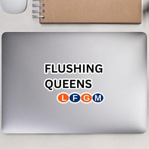 Puede incluir: Un ordenador portátil plateado con una pegatina que dice "Flushing Queens" y tiene un logotipo de metro estilizado con las letras "L F G M".