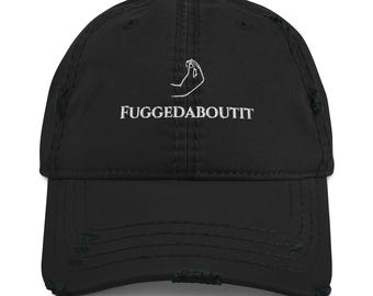 May include: Black distressed baseball cap with white embroidered text and a hand gesture. The text reads "FUGGEDABOUTIT". The cap has a curved brim and a distressed, worn look.