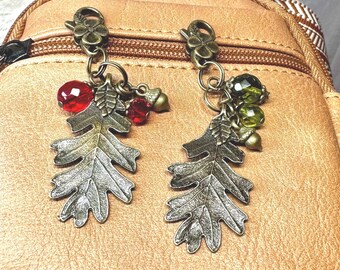May include: Two antique gold-toned oak leaf zipper pulls with red and green glass beads and acorn charms.