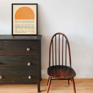 Poster featuring Ralph Waldo Emerson's inspirational quote 'Write it on your heart...' with a warm sun illustration, displayed in a black frame.