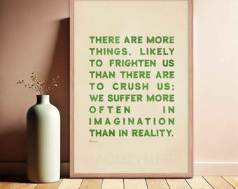 May include: A framed print with a green text quote on a cream background. The quote reads: "There are more things, likely to frighten us than there are to crush us; we suffer more often in imagination than in reality."