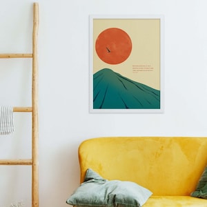 May include: A minimalist poster with a mountain and a red sun in the background. The quote "Wherever life plants you, bloom with grace" is printed in black text.