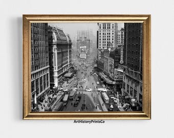 Könnte beinhalten: Schwarz-Weiß-Druck in einem Rahmen, der eine geschäftige Stadtstraßenszene zeigt. Das Bild zeigt eine Vintage-Ansicht einer Stadtstraße mit Autos, Bussen und Fußgängern. Gebäude säumen die Straße, und Werbetafeln sind sichtbar. Der Druck ist in einem goldfarbenen Rahmen.