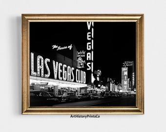 May include: Black and white framed print of the Las Vegas Club at night. The neon sign reads "LAS VEGAS CLUB" with "The House of" above it. Classic cars line the street. The "VEGAS" sign is vertical.