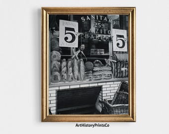 Può includere: Stampa incorniciata in bianco e nero di una vetrina di panetteria. La vetrina mostra pagnotte di pane e un cartello con la scritta "Bread 5 a loaf". Il nome della panetteria, "A. Zito Bakery", è visibile sopra la vetrina.