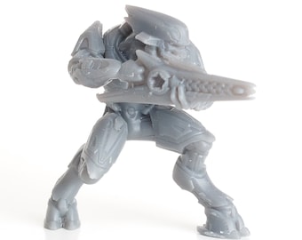 May include: A gray plastic action figure of an alien warrior holding a futuristic weapon. The figure is posed in a dynamic stance, ready for battle.