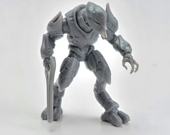 May include: Gray plastic action figure of a Halo Elite with a large energy sword. The figure is posed in a fighting stance with one leg forward and the other leg back.