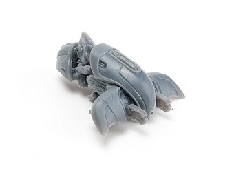 Könnte beinhalten: Ein graues Plastikmodell eines futuristischen Raumschiffs mit detailliertem Design. Das Raumschiff hat einen abgerundeten Körper und zwei Flügel.