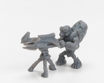 Peut inclure: Figurine miniature grise d'un soldat extraterrestre futuriste tenant une arme montée sur un trépied. Le soldat a une conception blindée détaillée avec un grand sac à dos et un casque avec plusieurs lentilles. L'arme a un design élégant et angulaire.