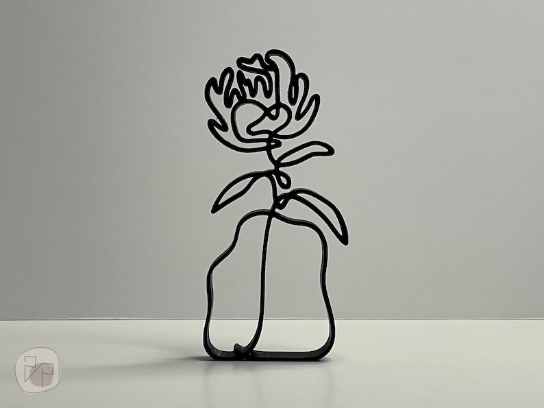 May include: A black metal sculpture of a flower in a vase. The flower is stylized and has a simple, modern design.