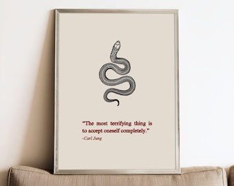 May include: A framed wall art print featuring a black line-art illustration of a snake centered on a light beige background. Below the snake, the text reads: "The most terrifying thing is to accept oneself completely." followed by "-Carl Jung".