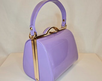 Bolso de mano de noche adornado con asa superior clásica de charol lila morado