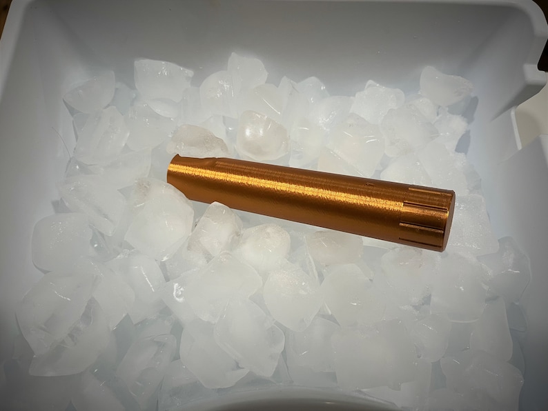 K&ouml;nnte beinhalten: Ein kupferfarbenes Metallrohr liegt auf einem Bett aus Eisw&uuml;rfeln in einem wei&szlig;en Plastikbeh&auml;lter.