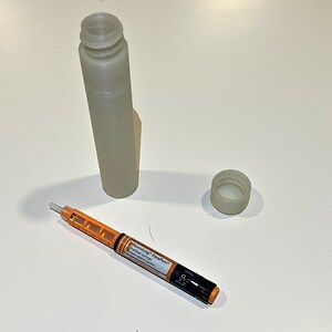 K&ouml;nnte beinhalten: Eine wei&szlig;e Plastikflasche mit einem wei&szlig;en Deckel und einem kleinen orangefarbenen und wei&szlig;en stiftartigen Ger&auml;t mit dem Text "NovoLog&reg; FlexPen&reg; Insulin Aspart" darauf.