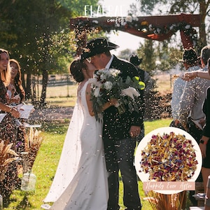 May include: A wedding scene with a bride and groom kissing under a wooden arch decorated with flowers. Confetti is being thrown in the air. A bouquet of white and red flowers is held by the groom. A circular image of dried flower confetti is in the foreground.