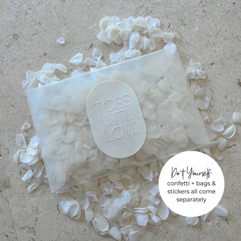 May include: A translucent packet filled with white confetti, sealed with an oval sticker reading "Toss With Love." The packet is surrounded by scattered confetti. Text in a circle reads "Do it Yourself confetti + bags & stickers all come separately."