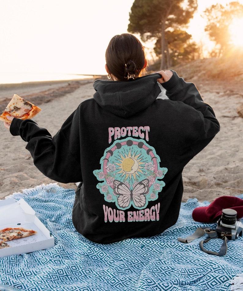 May include: Black hooded sweatshirt with a graphic print of a butterfly, sun, moon, and the text "Protect Your Energy".