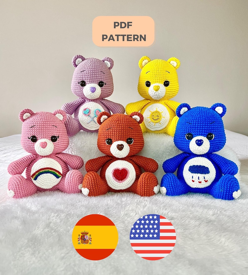 May include: Five crocheted Care Bear plush toys in different colours: pink, purple, yellow, orange, and blue. Each bear has a unique symbol on its belly: a rainbow, a lollipop, a sun, a heart, and a cloud with raindrops. The bears are sitting on a white fluffy surface. PDF PATTERN.