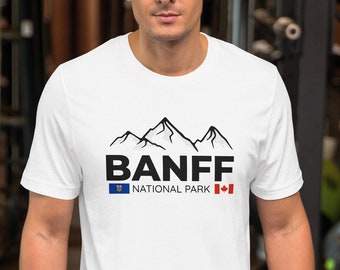 May include: White t-shirt with a black graphic of mountains and the text "Banff National Park" with the Canadian and Alberta flags.