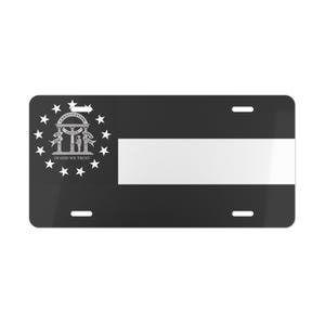 May include: Black license plate with a white stripe and the Georgia state seal. The seal includes the words "Constitution, Justice, Wisdom, Moderation" and "In God We Trust" surrounded by stars.