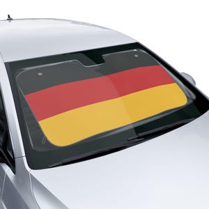 Op de afbeelding: Een auto zonnescherm met de Duitse vlag. Het ontwerp toont de kleuren van de vlag: zwart, rood en geel. Het zonnescherm is geïnstalleerd in de voorruit van een zilveren auto, en biedt bescherming tegen de zon en een patriottisch ontwerp.
