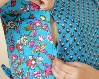 Könnte beinhalten: Ein blaues Kleid mit Blumenmuster und einem Reißverschluss zum Stillen. Das Kleid hat einen Gürtel an der Taille und ein kleines Blumenmuster auf dem Oberteil.