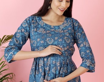 Könnte beinhalten: Ein blaues, knielanges Kleid mit einem sich wiederholenden Blumenmuster in Hellbraun und Weiß. Das Kleidungsstück hat einen Rundhalsausschnitt, Dreiviertelärmel und eine geraffte Taille, was für eine strukturierte Passform mit ausgestelltem Rock sorgt.