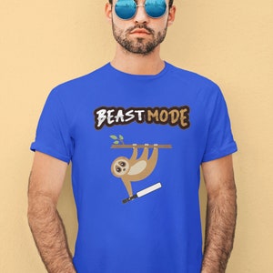 May include: A royal blue t-shirt with the text "BEAST MODE" in brown and white lettering. A cartoon sloth is hanging from a branch and holding a baseball bat.