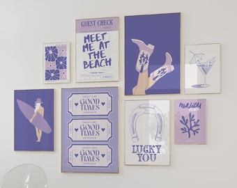 May include: A collection of nine purple and white framed prints with various designs, including a horseshoe, a surfboard, a ticket stub, a cowboy boot, and a cocktail glass. The prints have gold frames and are arranged on a white wall.