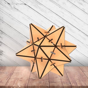 Peut inclure: Une sculpture géométrique en bois en forme d'étoile avec une finition brun clair et des lignes noires. La sculpture est composée de plusieurs morceaux de bois assemblés pour créer une forme tridimensionnelle.