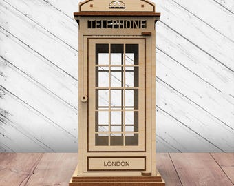 May include: A wooden model of a classic red British telephone booth. The booth is detailed with a crown on top, the word "TELEPHONE" on the front, and the word "LONDON" on the bottom.