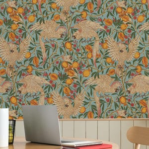 May include: A room with a round wooden table, chairs, and a patterned wallpaper. The wallpaper features a repeating design of birds, oranges, and foliage in shades of brown, orange, and green against a blue background. A laptop and lamp are on the table.