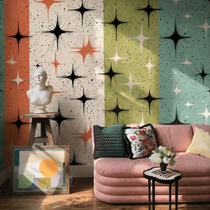 Può includere: Carta da parati con un motivo ripetitivo di stelle nere e arancioni su sfondi color crema, verde e verde acqua con macchie nere. Il design include un busto bianco su un supporto in legno, una stampa astratta incorniciata e un divano a righe rosa.