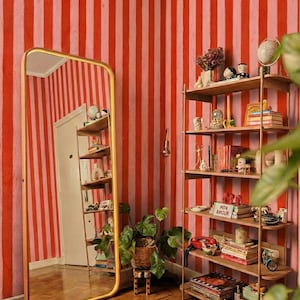 Puede incluir: Una taza de cerámica blanca con un asa negra y el texto "But First, Coffee" en negro, con una fuente de estilo manuscrito. La taza está sobre una superficie blanca.