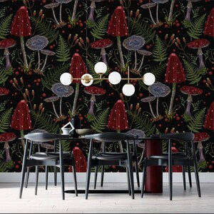 May include: A black and white dining room with a black table and six black chairs. The wall is covered in a red and green mushroom wallpaper.