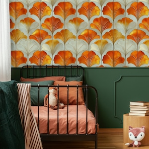 May include: A black metal bed frame with a green headboard and a peach-colored bedspread. The wall behind the bed is covered in a wallpaper with a repeating pattern of orange and white ginkgo leaves. There are books stacked on a wooden side table next to a potted plant.
