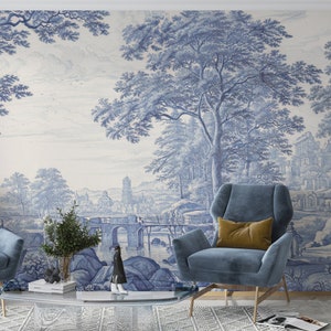 Puede incluir: Un interior de sala de estar con dos sillones azules y una mesa de caf&eacute;. La pared est&aacute; decorada con un papel tapiz azul y blanco que representa un paisaje con &aacute;rboles, un puente y una ciudad en la distancia.