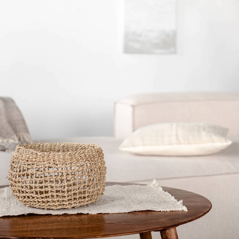 Runder Seegras Korb Bola auf Couchtisch im Wohnzimmer, dekorativ eingesetzt als Aufbewahrung mit natürlicher Netzstruktur